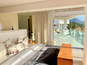 a bedroom with a white bed and a balcony at Clifton YOLO Spaces - Clifton Beachfront Penthouse in Cape Town