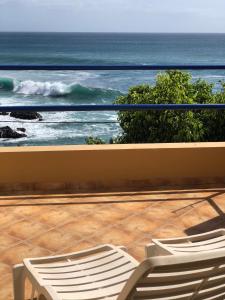 dwa krzesła na balkonie z widokiem na ocean w obiekcie Splendid Guest Suite with Separate Private Ocean View Terrace w mieście Praia