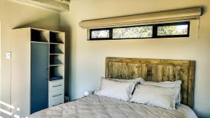 a bedroom with a bed with a wooden headboard and a window at Lodge @ Bankenkloof Private Game Reserve in Tierpoort
