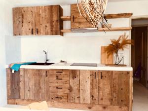 a kitchen with wooden cabinets and a sink at Can Petit - Romantic & Cozy Villa in Sant Ferran de Ses Roques