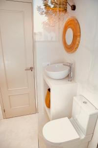 a bathroom with a sink and a toilet and a mirror at Can Petit - Romantic & Cozy Villa in Sant Ferran de Ses Roques