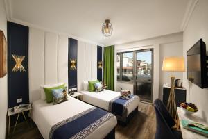 a hotel room with two beds and a television at Hotel Ephesus Istanbul in Istanbul