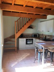 a kitchen with a wooden staircase and a table at Castel Mireio Gîtes in Cairanne