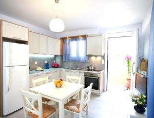 a kitchen with a white table and white cabinets at Muses Studios Sami in Sami
