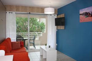 ein Wohnzimmer mit einem roten Sofa und einem Fenster in der Unterkunft Résidence du Parc Hossegor in Hossegor