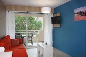 a living room with a red couch and a window at Résidence du Parc Hossegor in Hossegor