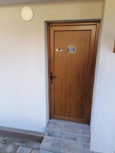une porte en bois avec une vignette placée dans un couloir dans l'établissement Forest Andrijana, à Zlatibor