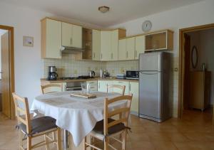 a kitchen with a table with chairs and a refrigerator at Apartments Smolica in Labin