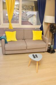 a living room with a couch and a coffee table at APPARTEMENT ENTRE GENÈVE ET CHAMONIX AU PIED DES MONTAGNES in Cluses