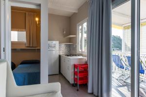 a small kitchen with a view of a balcony at Resort Baia del Silenzio in Pisciotta