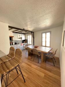 cocina y comedor con mesa de madera y sillas en Appartement idéalement situé Ax-les-thermes, en Ax-les-Thermes