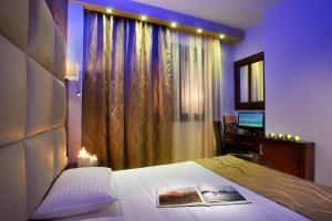 a bedroom with a bed and a window with a television at 4- you Family in Metamorfosi