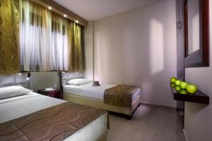 a hotel room with two beds and a window at 4- you Family in Metamorfosi