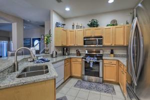 a kitchen with wooden cabinets and a stainless steel refrigerator at Disney Villa with Game Room and Pool - 10 Mi to Parks! in Orlando