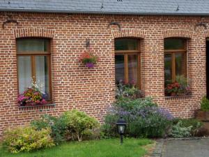 a brick building with three windows with flower boxes at La Forge De Labbaye in Liessies +16 photos