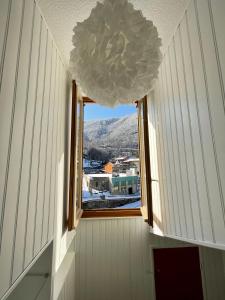 a window in a room with a chandelier at Appartement idéalement situé Ax-les-thermes in Ax-les-Thermes