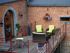 eine Terrasse mit Stühlen und Ziegelwand in der Unterkunft La Forge De Labbaye in Liessies