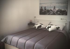 a bedroom with a bed with black and white pillows at Satyria Apartments in Taranto