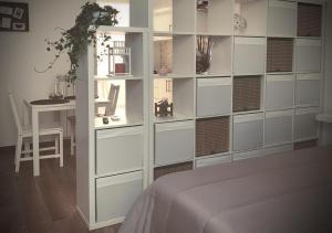 a bedroom with a wall of drawers and a table at Satyria Apartments in Taranto