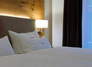 Schlafzimmer mit einem Bett mit weißer Bettwäsche und Kissen in der Unterkunft Höger's Hotel & Restaurant in Bad Essen