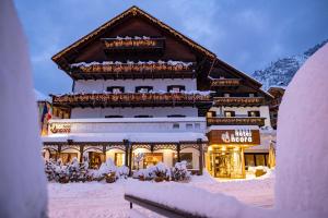 a ski lodge in the snow in front at Active Hotel Ancora in Predazzo