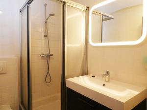 La salle de bains est pourvue d'un lavabo et d'une douche avec un miroir. dans l'établissement Hotel Café Restaurant De Posthoorn, à Dokkum