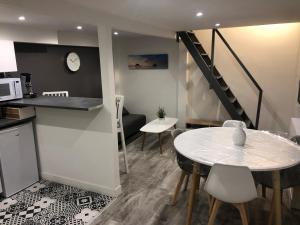 une cuisine et une salle à manger avec une table et un escalier dans l'établissement Jardin de la Béchade, à Bordeaux