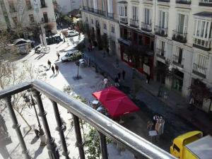 una vista aérea de una calle con una sombrilla roja en Hostal Alonso, en Madrid