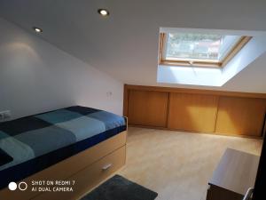 a bedroom with a bed and a window at Impresionantes vistas al mar cerca de Santiago in Boiro