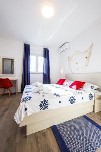 um quarto com uma cama grande com almofadas azuis e vermelhas em 1oak rentals 2 em Vir