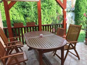 a wooden table and chairs on a patio at Lily House in Balatonvilágos