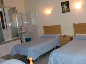 Habitación hospitalaria con 2 camas y lavamanos en Hostal Alonso, en Madrid