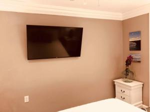 a bedroom with a flat screen tv on the wall at Elegant Marble Suite #6 in Nassau