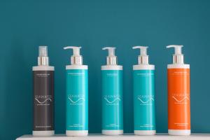a group of four shampoo bottles sitting next to each other at Seawater Hotel Bio & Beauty Spa in Marsala