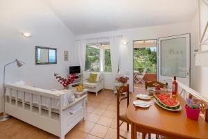 una sala da pranzo e un soggiorno con una culla e un tavolo di The Kantada Villas Petros, Eleni, Stelios & Dioni a Gaios