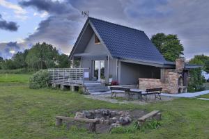 ein kleines Haus mit einer Bank davor in der Unterkunft Domek Gościnny in Darłowo