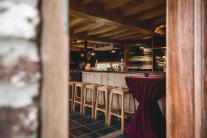 un bar con taburetes de madera y una mesa roja en Ruidenberg, en Kortemark