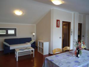 - un salon avec un canapé bleu et une table dans l'établissement Casa Vittoria V2, à Crone