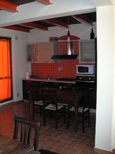 a kitchen with a table and chairs and a microwave at Agriturismo Zaffamaro in Beroide