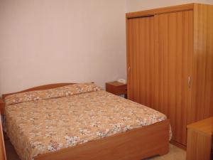 1 dormitorio con 1 cama y armario de madera en CASA FRAMARCHI, en Lido Marini