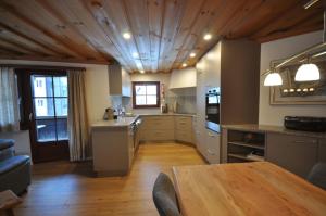 a kitchen with a wooden ceiling and a wooden table at Chasa Sager 2 in Scuol