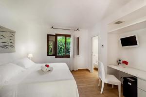 a white bedroom with a white bed and a desk at Hotel Villa Mediterranea in Noto Marina