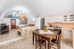 a kitchen and living room with a table and a couch at Kokos Traditional Houses in Emporio Santorini