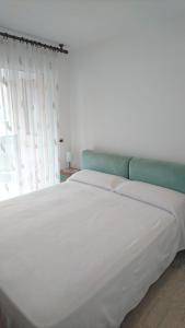 1 cama blanca grande en una habitación con ventana en K&S 68 Appt Standing vue mer - Garage Inclus en Roquebrune-Cap-Martin