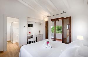 a white bedroom with a white bed and a desk at Hotel Villa Mediterranea in Noto Marina