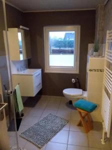 a bathroom with a sink and a toilet and a window at Haus Rose in Nortorf +18 photos