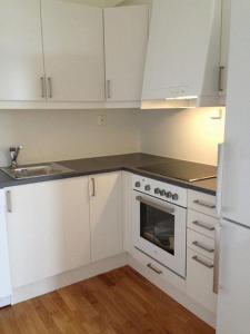 a kitchen with white cabinets and a sink and a refrigerator at City Apartment Fully Furnished - Lillestrøm-Strømmen in Lillestrøm