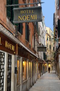 威尼斯的住宿－諾埃米酒店，建筑上一条空的街道,上面有酒店标志