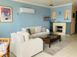 a living room with a white couch and a fireplace at Kadyanda Apartments in Fethiye