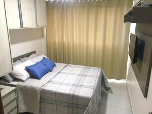Dormitorio pequeño con cama con almohadas azules en Beach Class Eco Life, en Porto de Galinhas